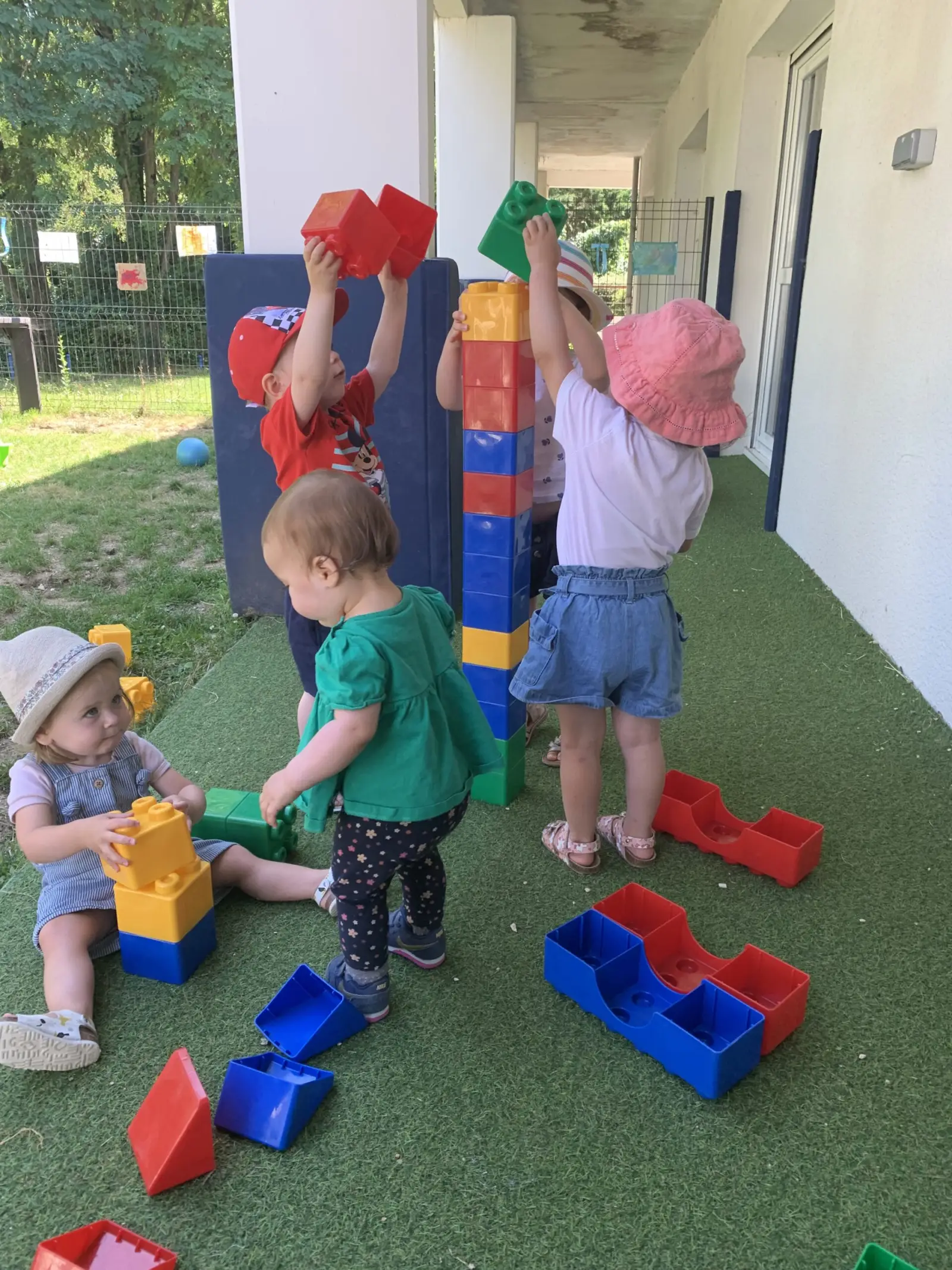 Enfants construisant une tour en briques géantes sur la terrasse de la micro-crèche de L'Houmeau