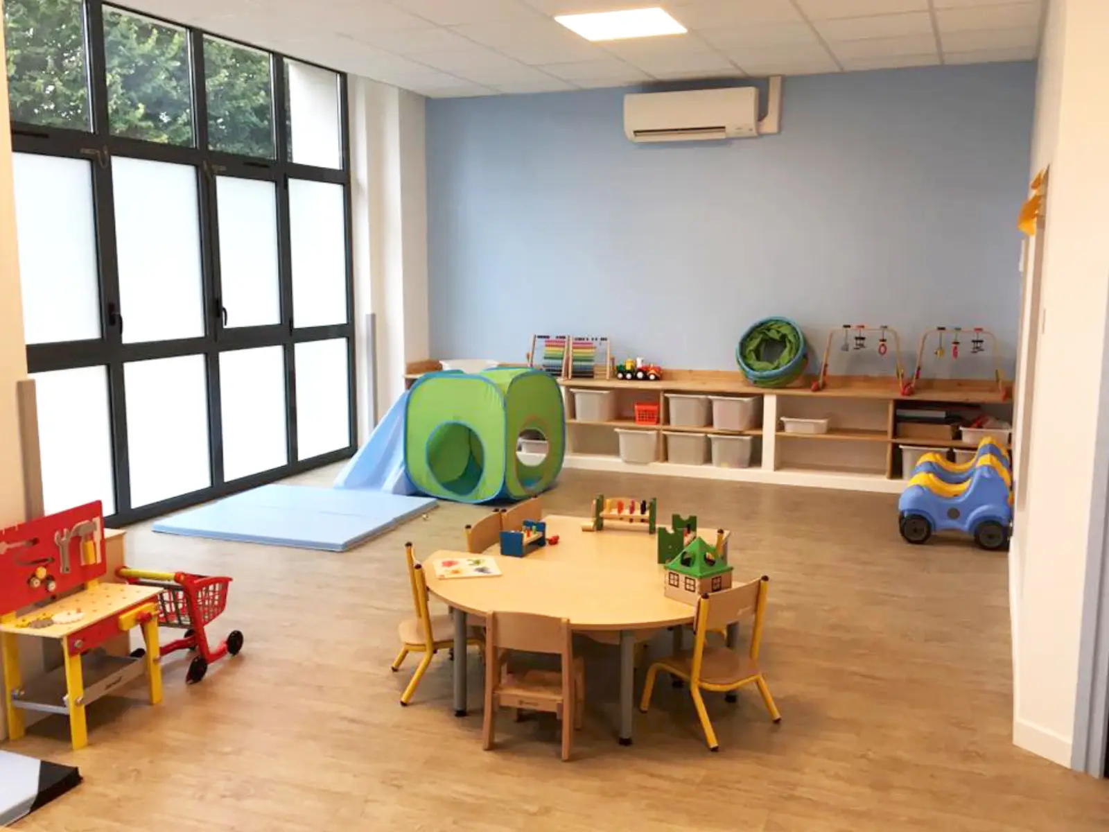 Salle de jeu avec toboggan et tunnel de motricité à la micro-crèche MicroStars d'Ermont