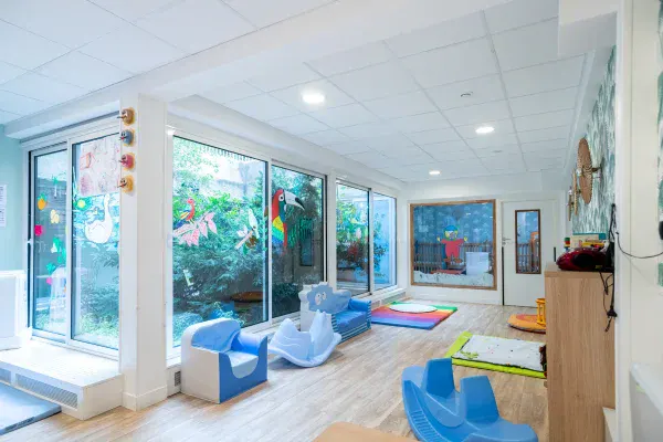 Salle d'éveil baignée de lumière de la micro-crèche Alésia à Paris 14e
