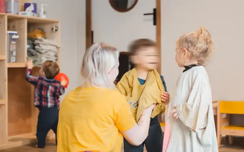 Enfants et professionnelle rangeant les jouets dans la micro-crèche Bonnetoile à Valence
