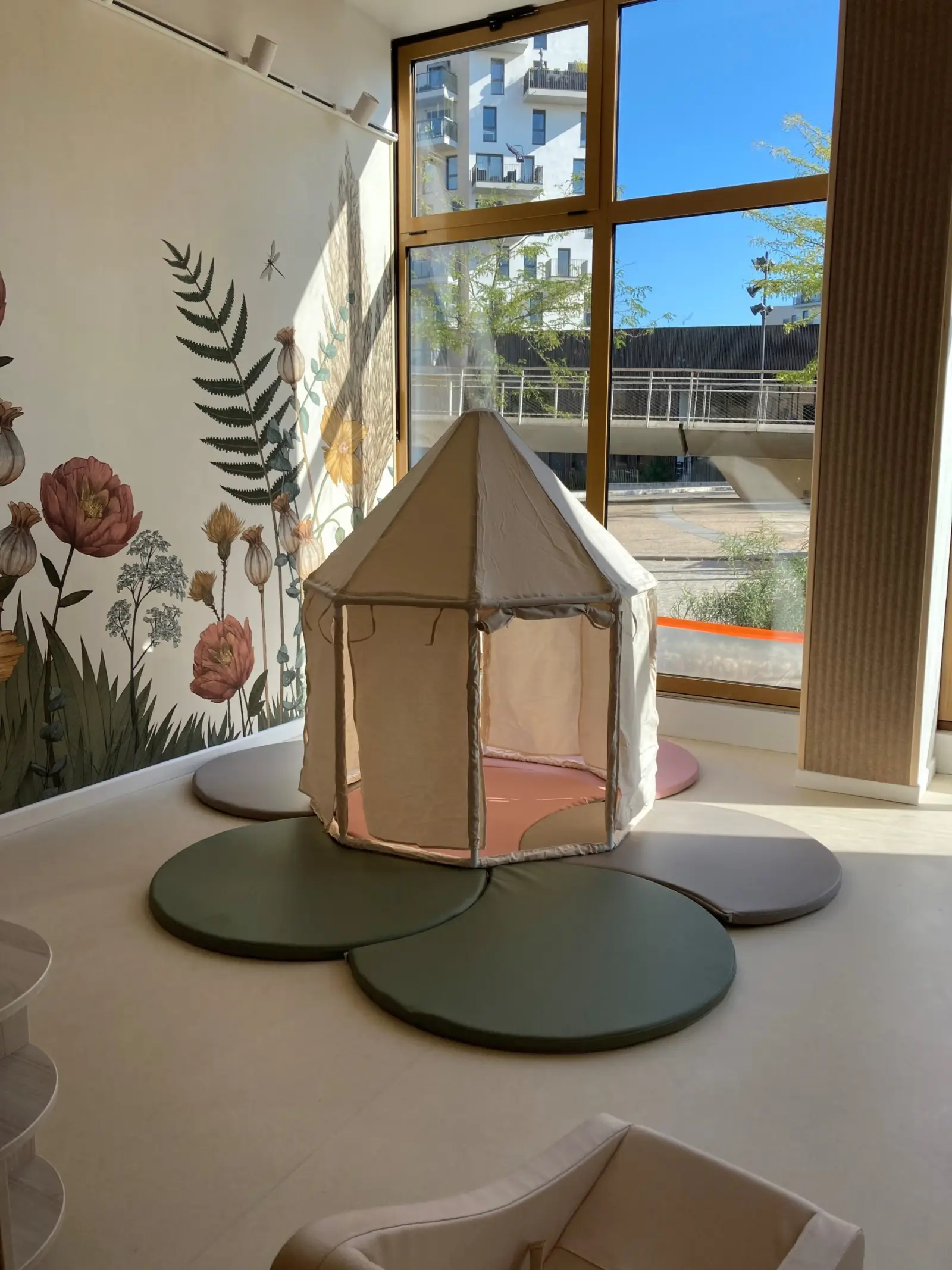 Cabane de jeu près des grandes baies vitrées de la crèche de Bobigny Écocité