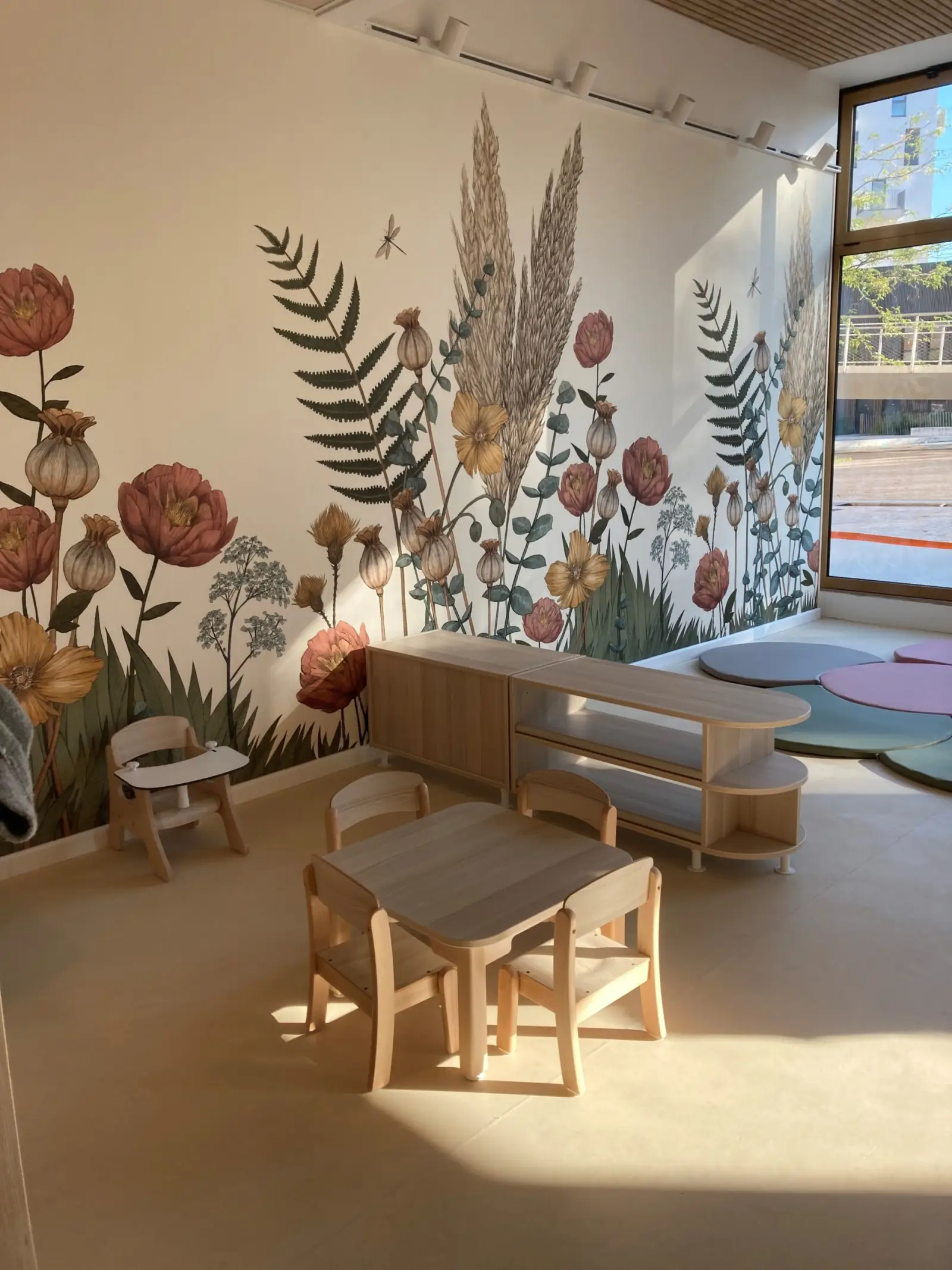 Fresque florale et coin de jeu calme à la crèche La Maison Kangourou Bobigny Écocité