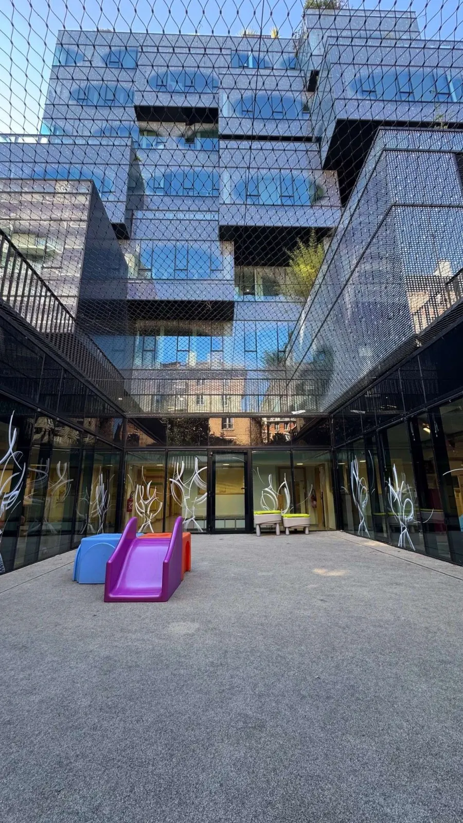 Cour extérieure sécurisée avec toboggan de la crèche La Maison Kangourou Peupliers à Paris 13e