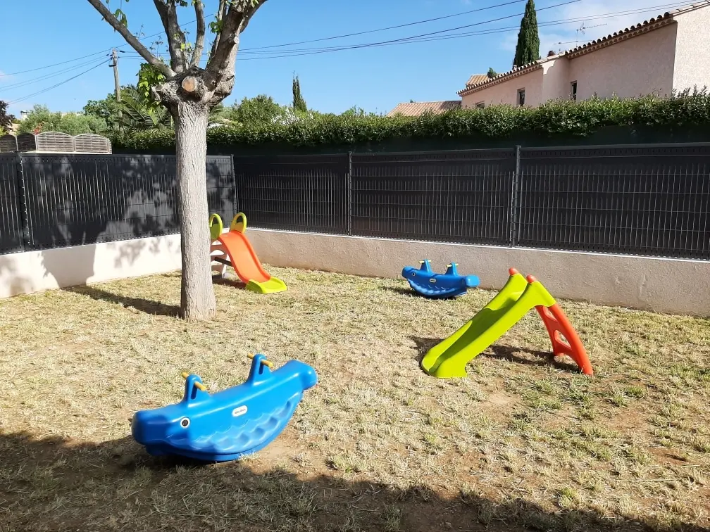 Jardin extérieur avec toboggans de la crèche Chapi Chapo à Clarensac