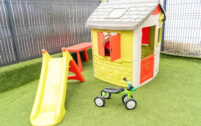 Espace de jeux avec coin dinette et vue sur le jardin extérieur à la micro-crèche Lou Mescladou