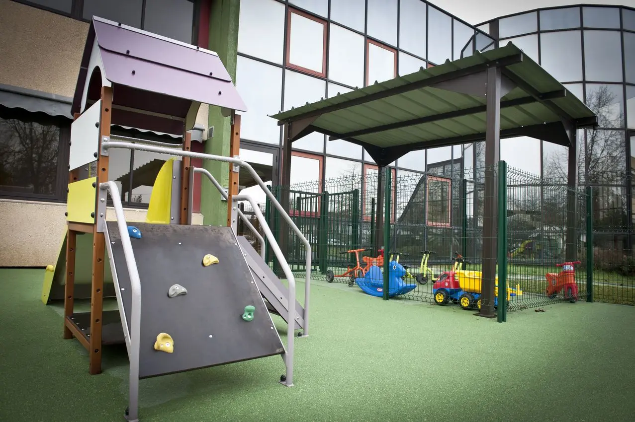 Structure de jeux extérieure avec toboggan et mur d'escalade à la crèche La Maison Kangourou Brive