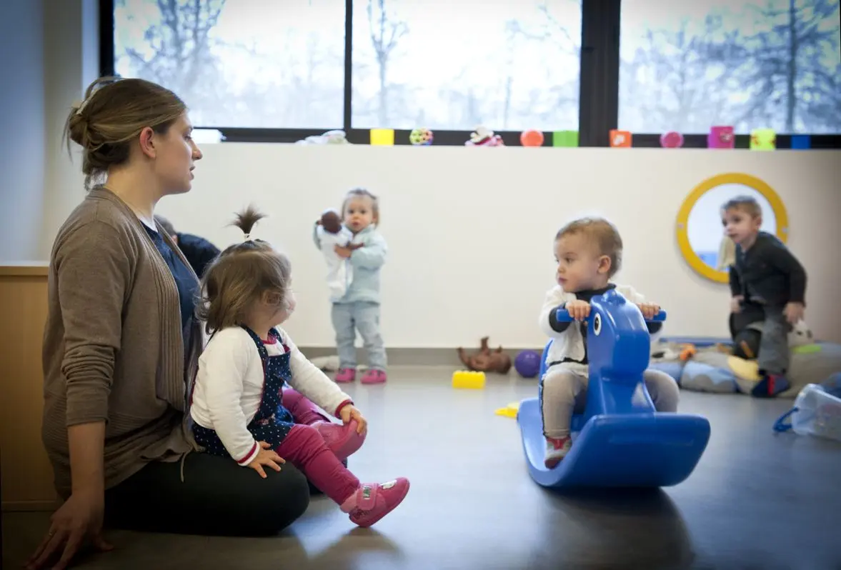 Enfants et éducatrice dans la salle de jeux de la crèche La Maison Kangourou Brive