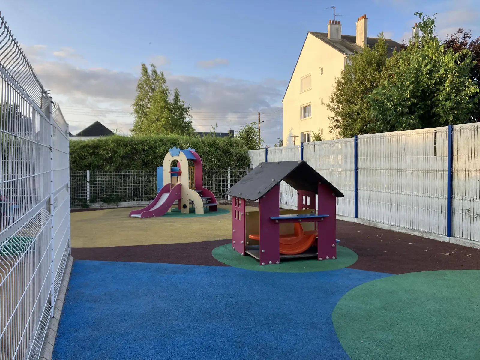 Cour extérieure avec jeux et cabane à la crèche de Trignac