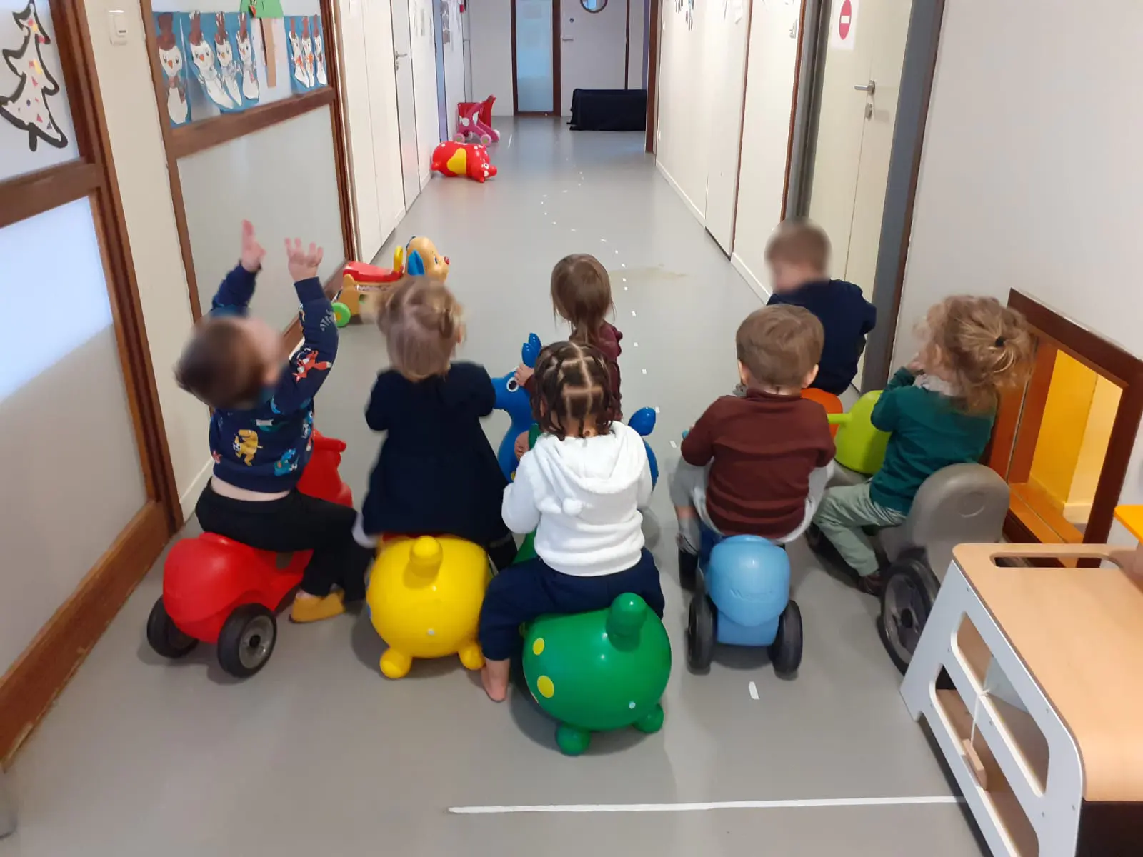 Enfants sur des jeux à porteurs dans le couloir du multi-accueil Coccinelle à Jarny
