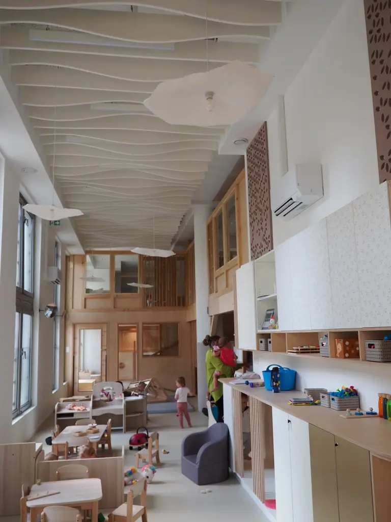 Ambiance de la salle de vie avec une professionnelle à la crèche La Maison Kangourou Roussel