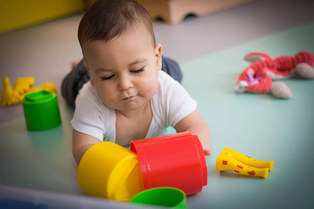 Bébé en plein éveil avec des jouets à la crèche La Maison Kangourou Voltaire
