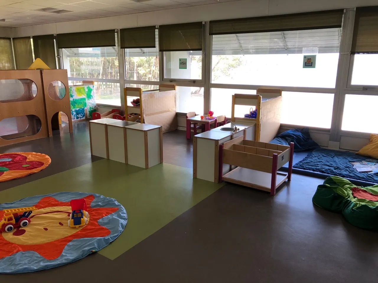 Salle de jeux et d'éveil de la crèche Bruges, avec vue sur les arbres du lac