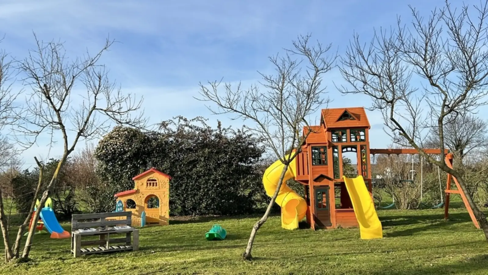 Jeux extérieurs dans le grand jardin arboré de la micro-crèche Les Petits Lutins de Malo