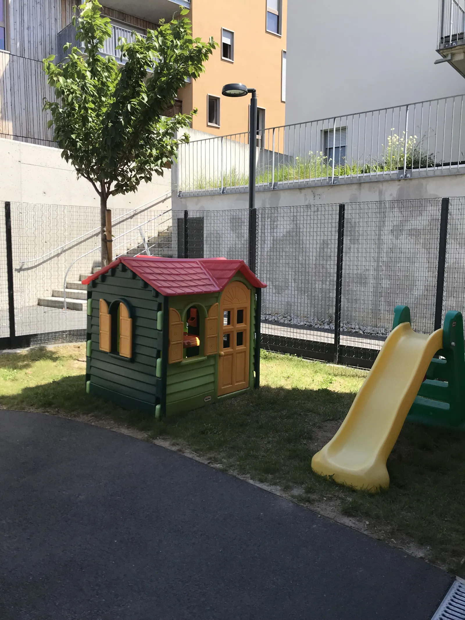 Jardin extérieur sécurisé avec toboggan et cabane à la micro-crèche Les P'tits Loupiots à Monistrol-sur-Loire