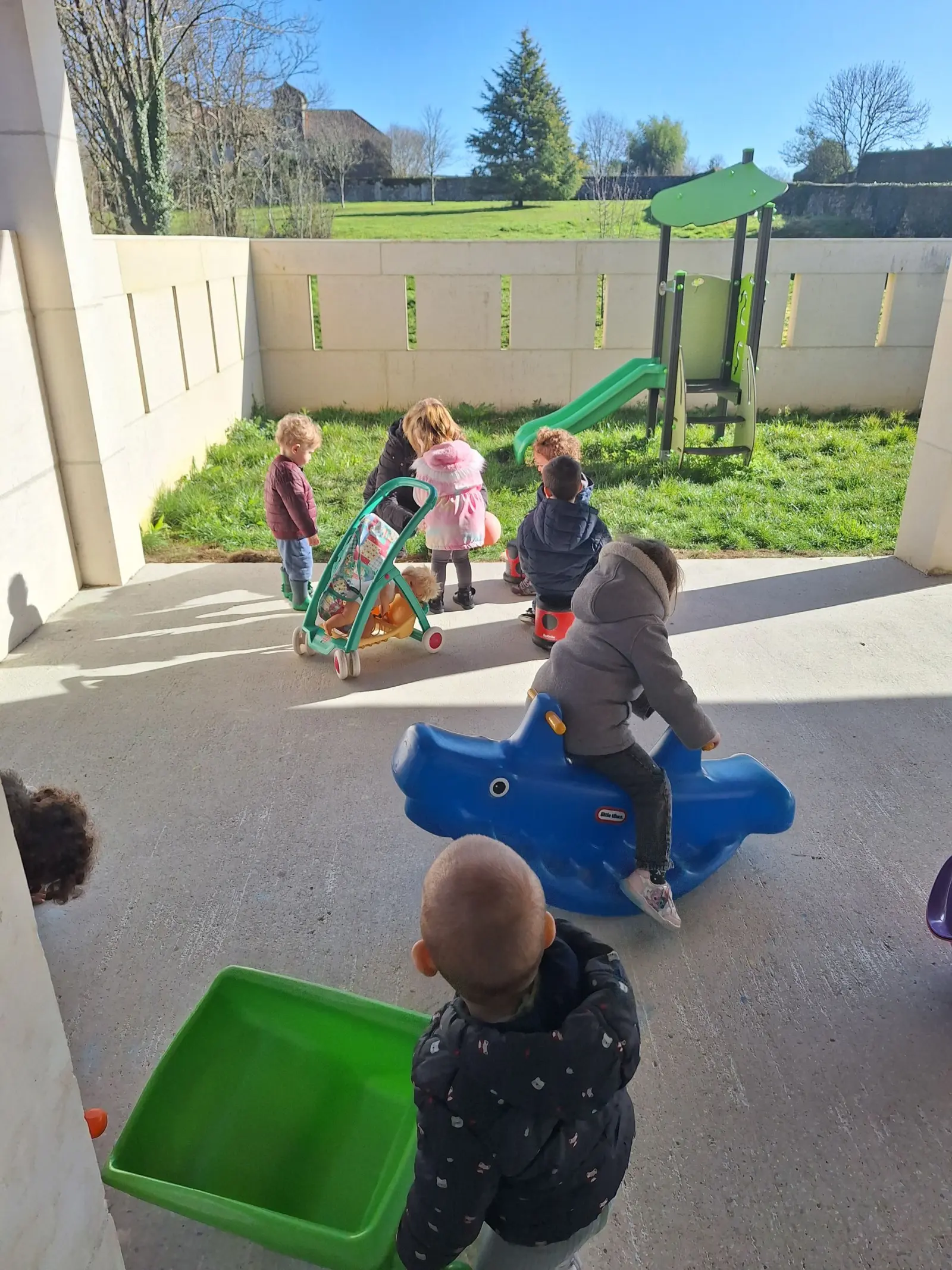 Enfants qui jouent sous le préau de la micro-crèche à Étagnac