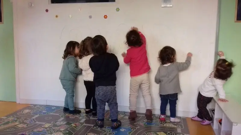 Les enfants dessinent ensemble sur le mur de la micro-crèche Les Chérubins du Crès