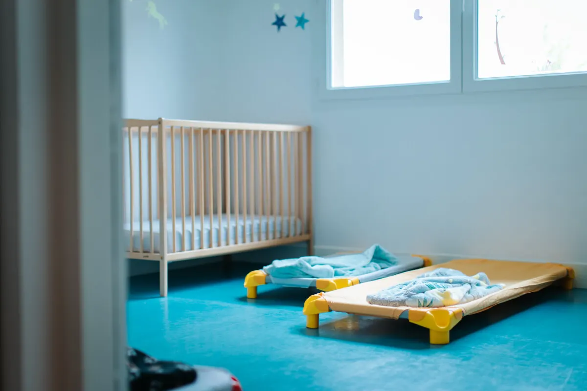Chambre de repos avec lits à barreaux à la Crèche des Minis à Cheyssieu