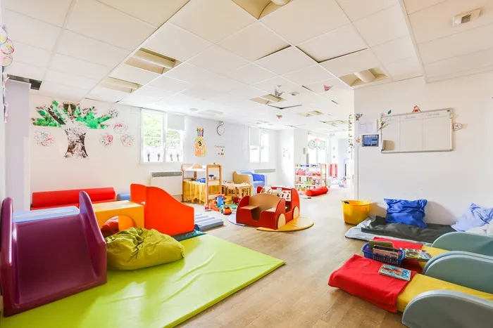 Salle de jeux et d'éveil de la crèche Plaisir avec tapis de motricité colorés
