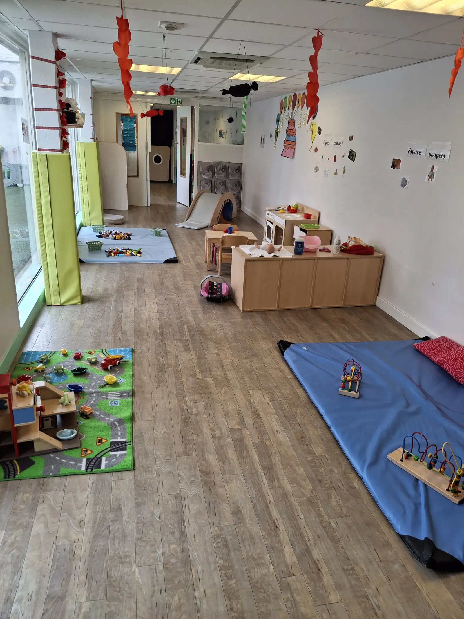 Salle de jeux et d'éveil de la crèche Saint Fons avec coin poupées et espace cuisine