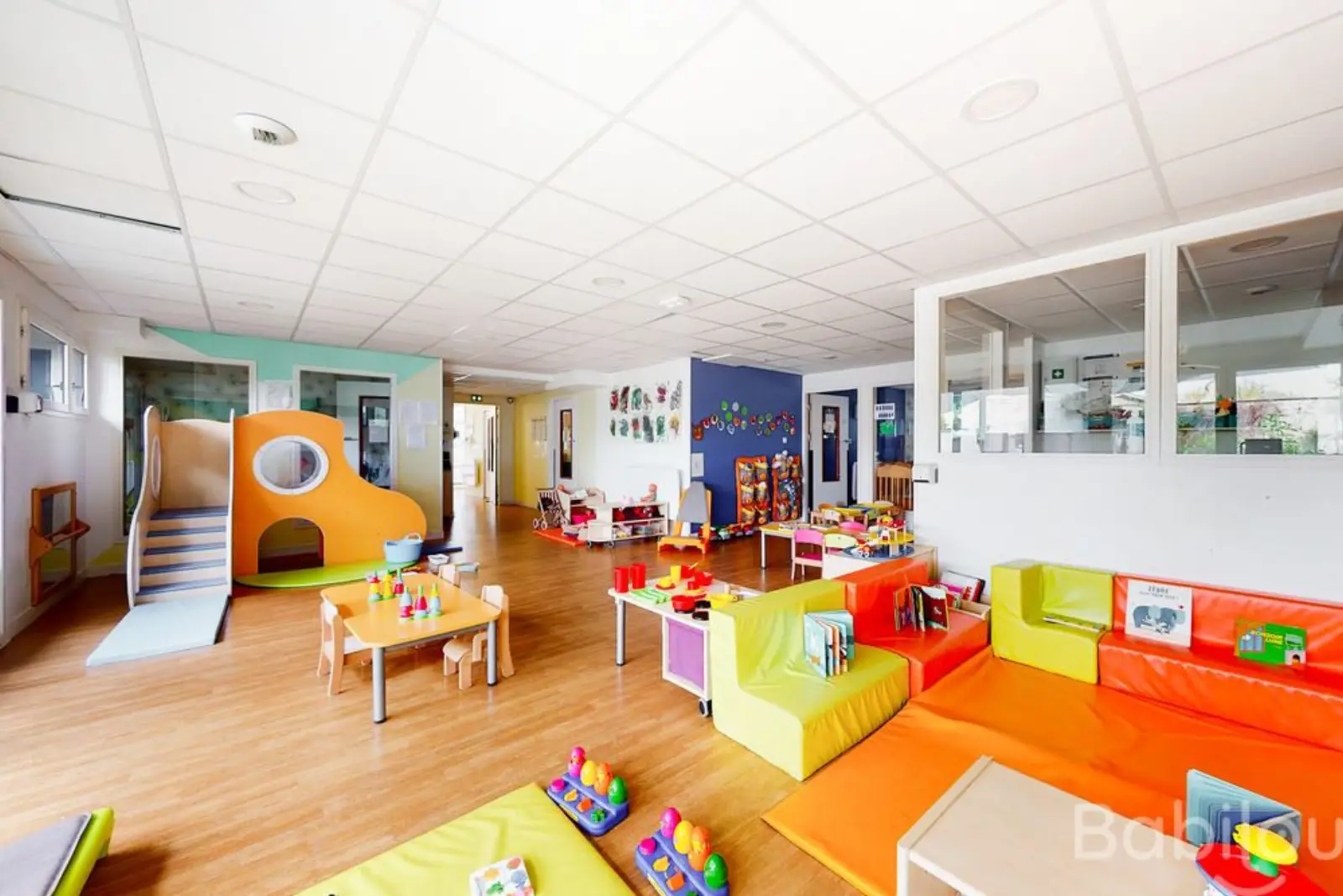 Grande salle de jeux avec toboggan à la crèche Babilou Paris Marie Blanche