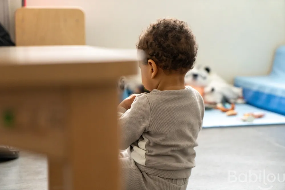 Enfant en exploration dans la salle de jeux de la micro-crèche Babilou Paris Hallé