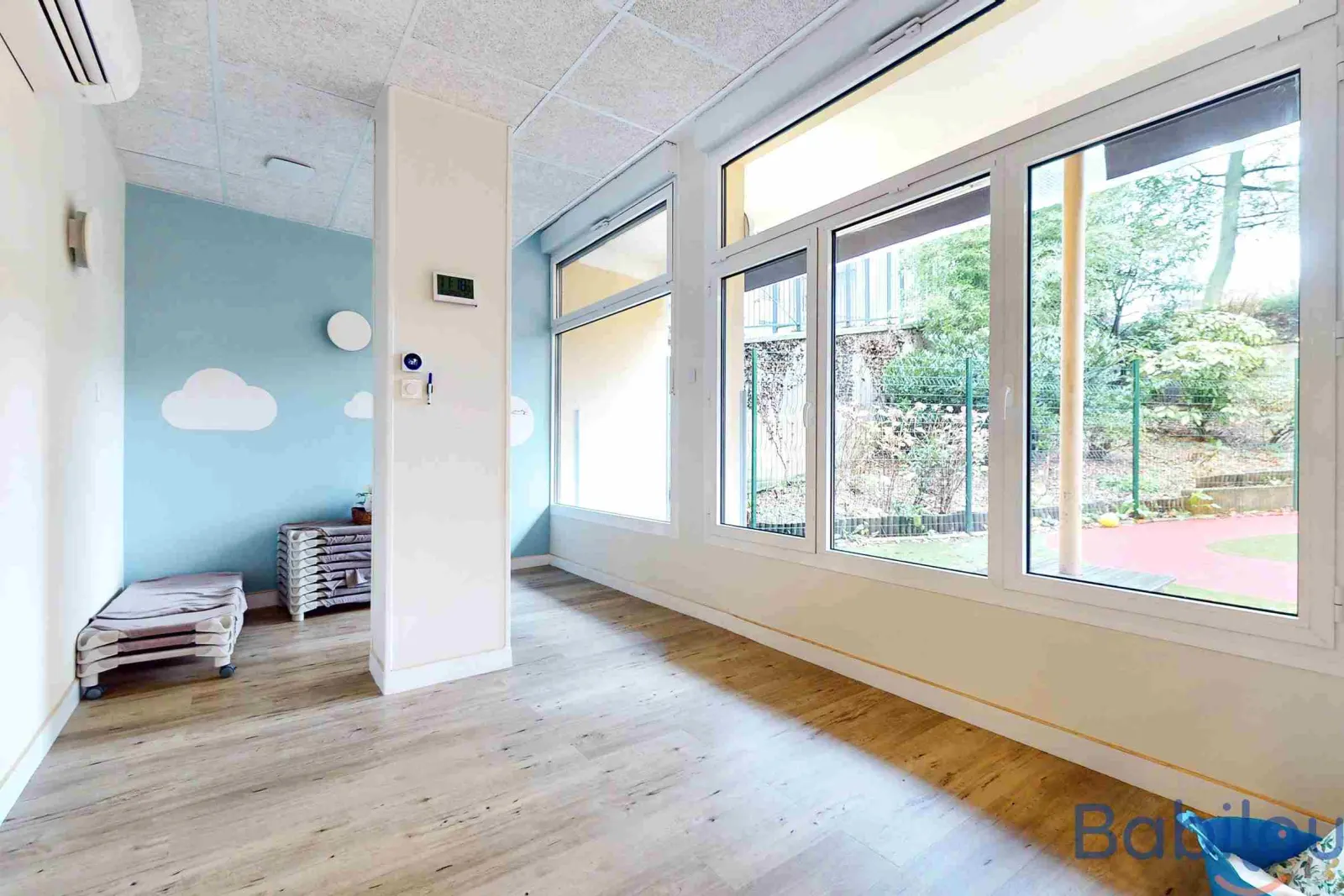 Espace de repos avec vue sur le jardin à la crèche Babilou Paris Alésia