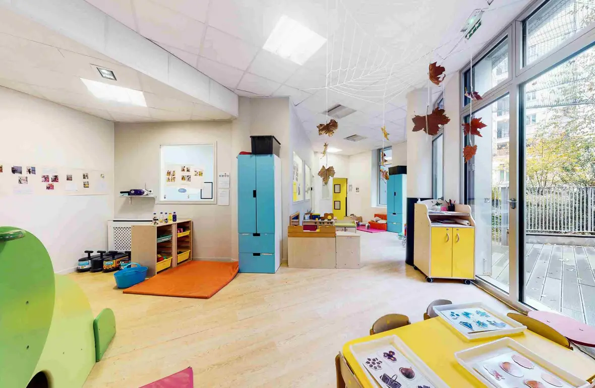 Salle de jeux et d'éveil donnant sur la terrasse à la crèche Babilou Paris Henri IV