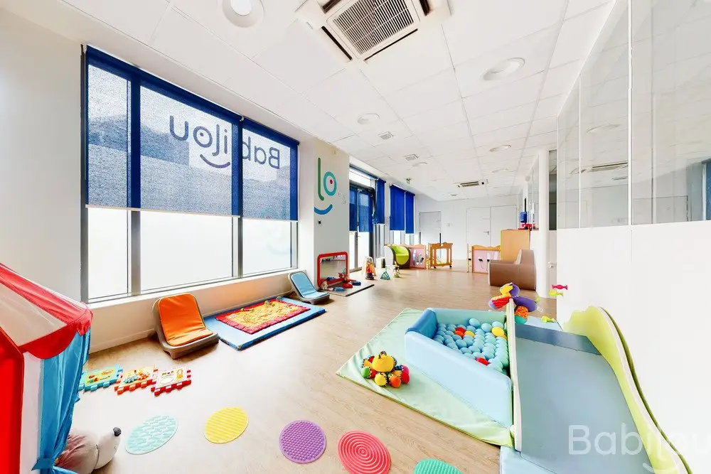 Salle de jeux avec toboggan et piscine à balles à la crèche Babilou Saint-Ouen Hugo
