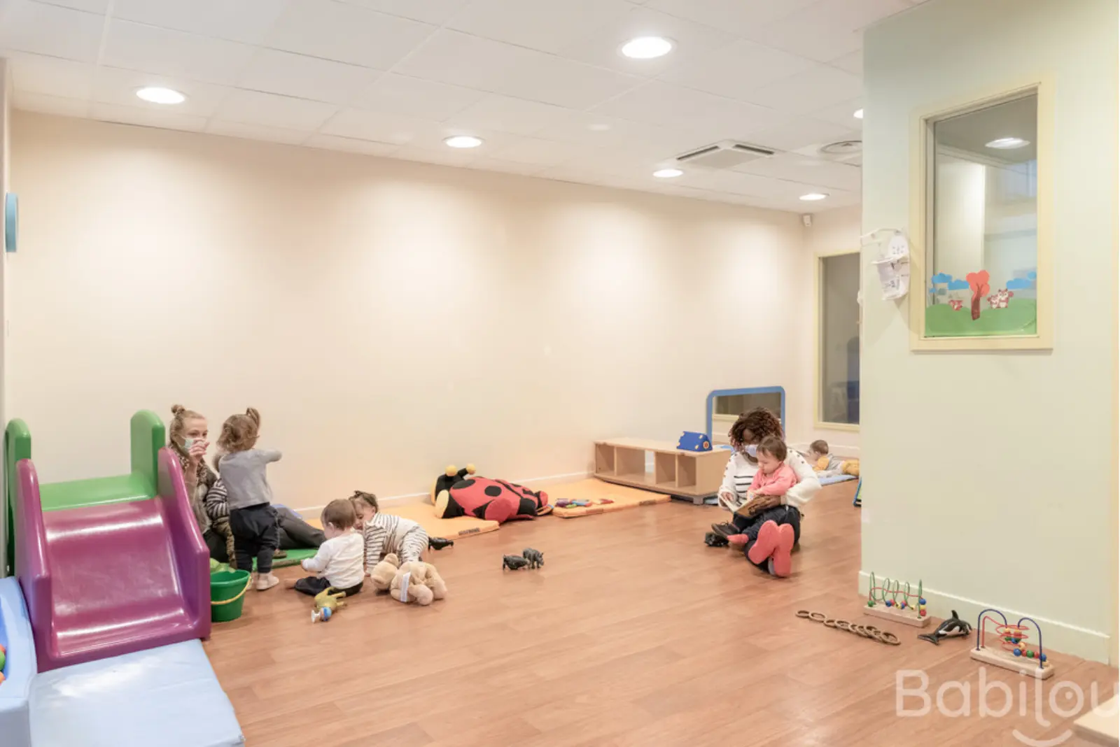 Salle de jeux avec toboggan à la crèche Babilou Paris Mauroy
