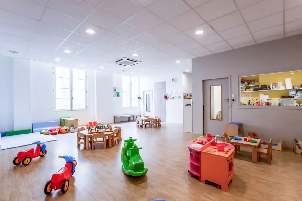 Salle de jeux et cuisine dinette à la crèche Babilou Paris Amsterdam
