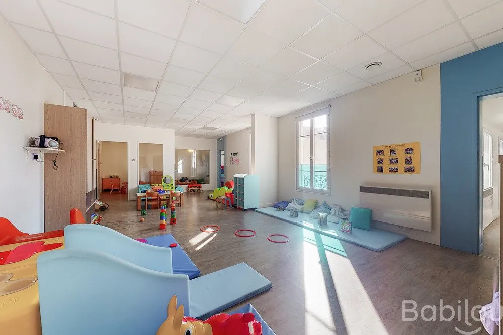 Espace de motricité avec tunnel et vue sur le dortoir à la crèche Babilou La-Garenne Glacière