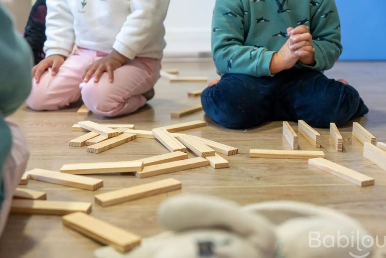 Enfants assis en cercle autour de jeux en bois