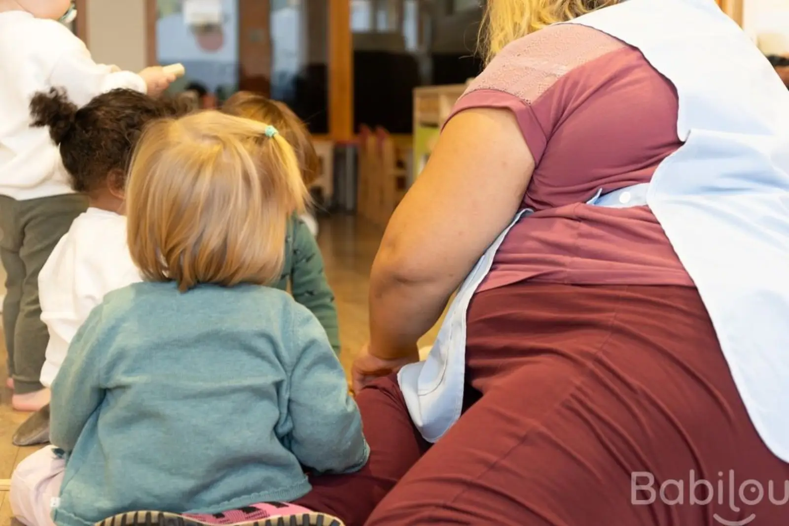 Groupe d'enfants encadrés par une professionnelle de la petite enfance
