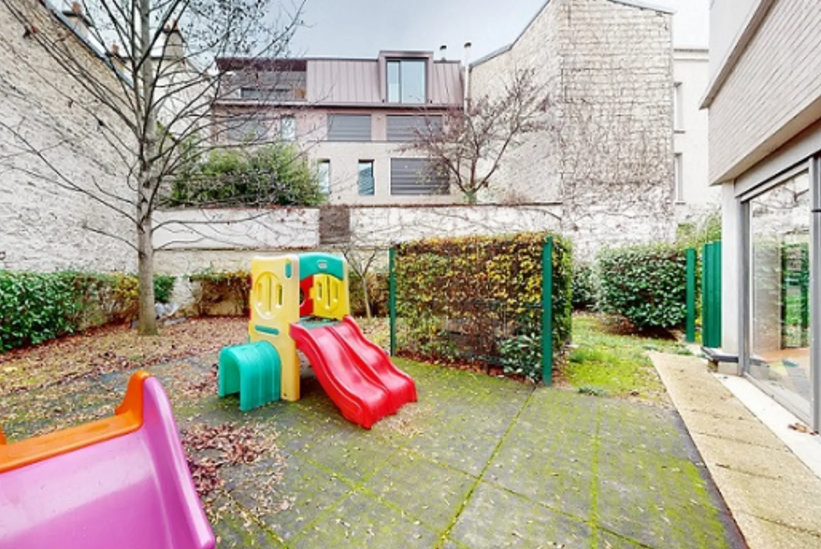 Jardin extérieur avec toboggan de la crèche Babilou Ivry Révolution