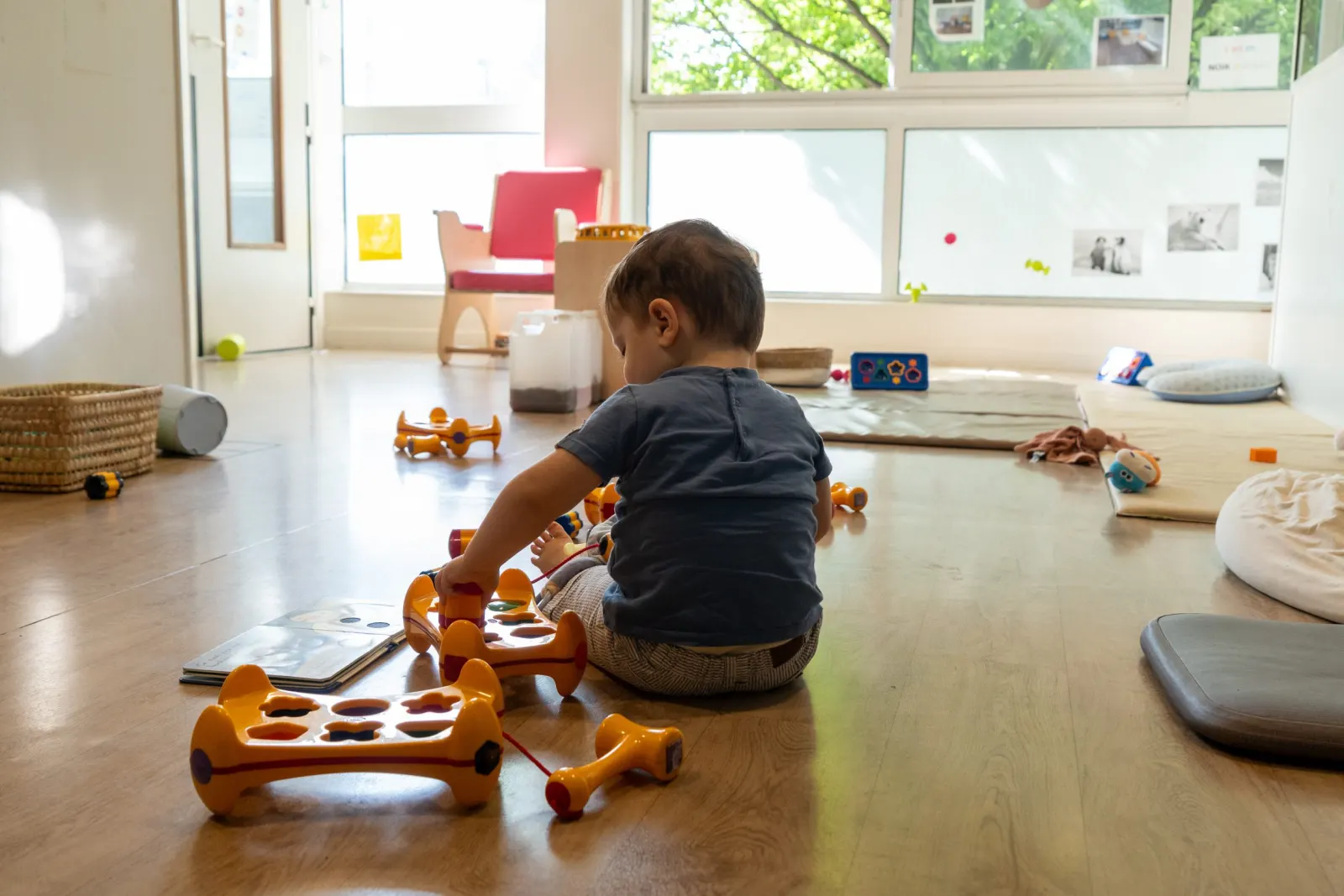 Bébé en pleine découverte d'un livre à la crèche Babilou Chelles Mitterrand