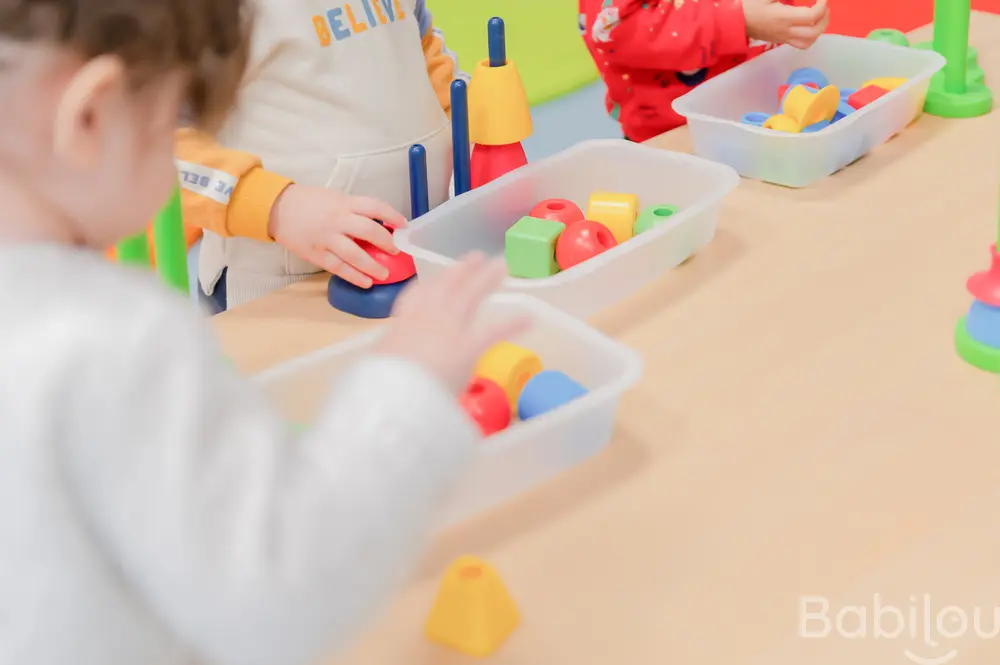 Enfants jouant avec des jeux d'encastrement à la crèche Babilou Argenteuil Chantal Goya