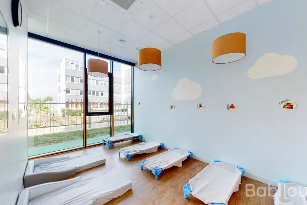 Dortoir décoré de nuages à la crèche Babilou Nantes Rondeau