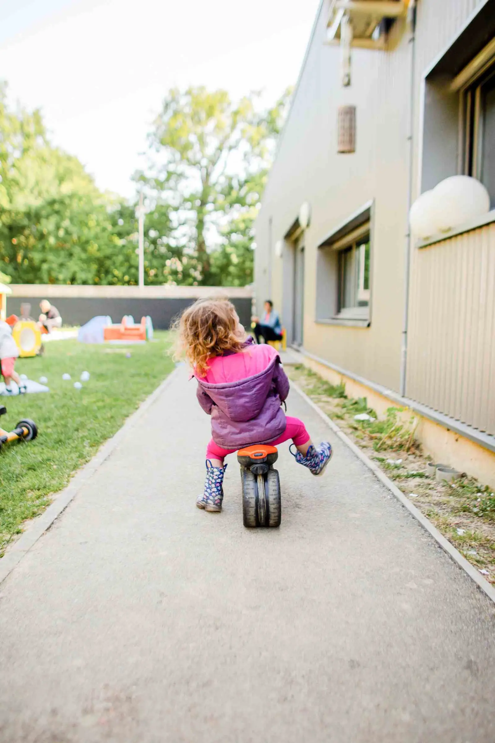 Enfants à tricycle dans le jardin de la crèche Babilou Saint-Grégoire Boutière