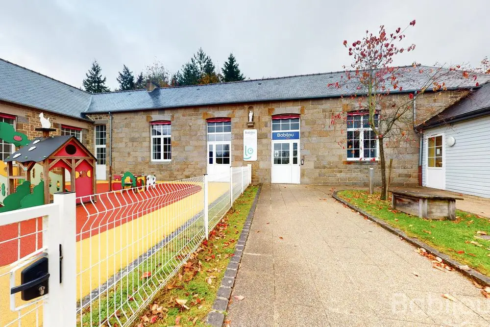 Façade en pierre et jardin sécurisé de la crèche Babilou Bonnemain Armorique