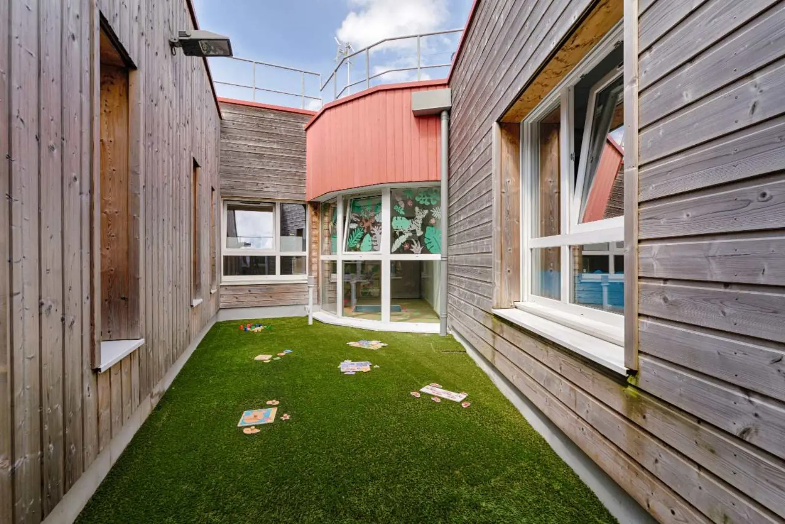 Patio extérieur avec pelouse de la crèche Pim Pam Pomme Bourguébus