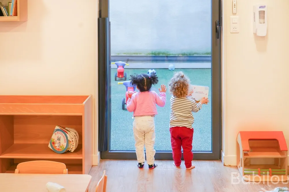 Enfants observant le jardin depuis la baie vitrée