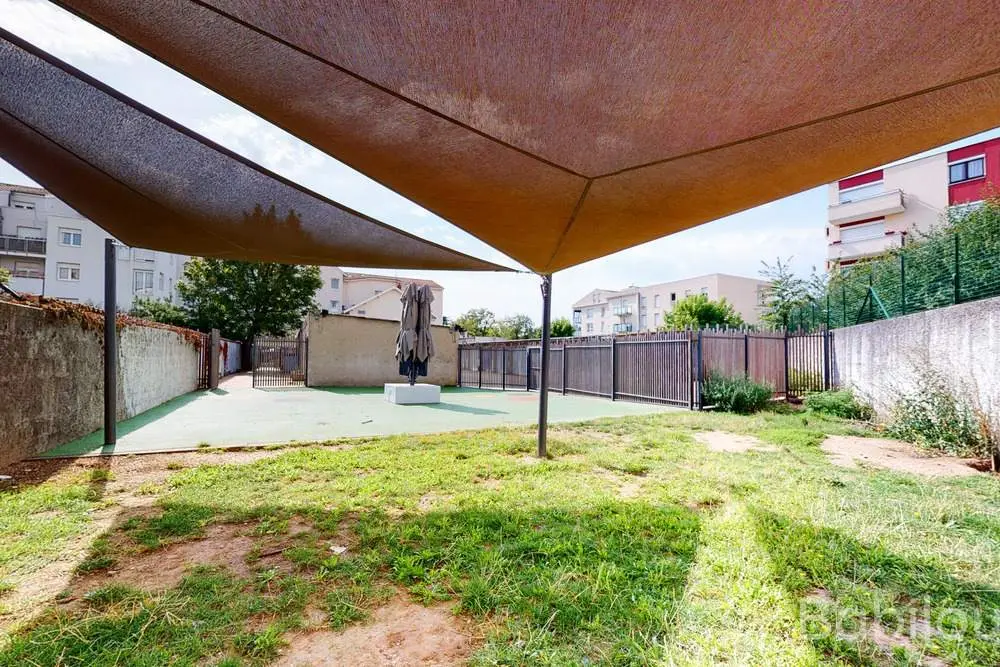 Terrasse extérieure ombragée de la crèche Babilou Saint-Priest Le Jardin de Pom d'Api
