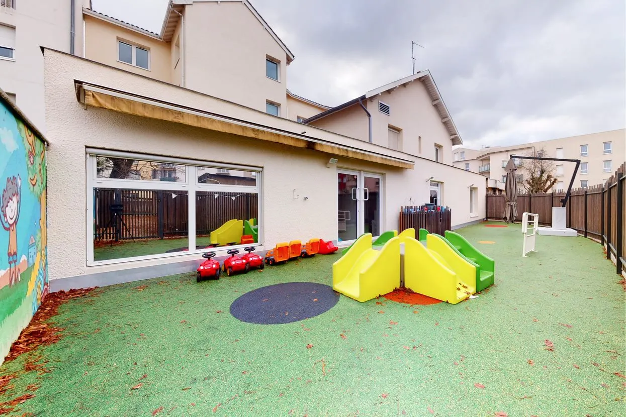 Cour extérieure avec toboggan et jeux de la crèche Babilou Saint-Priest Pic et Colegram