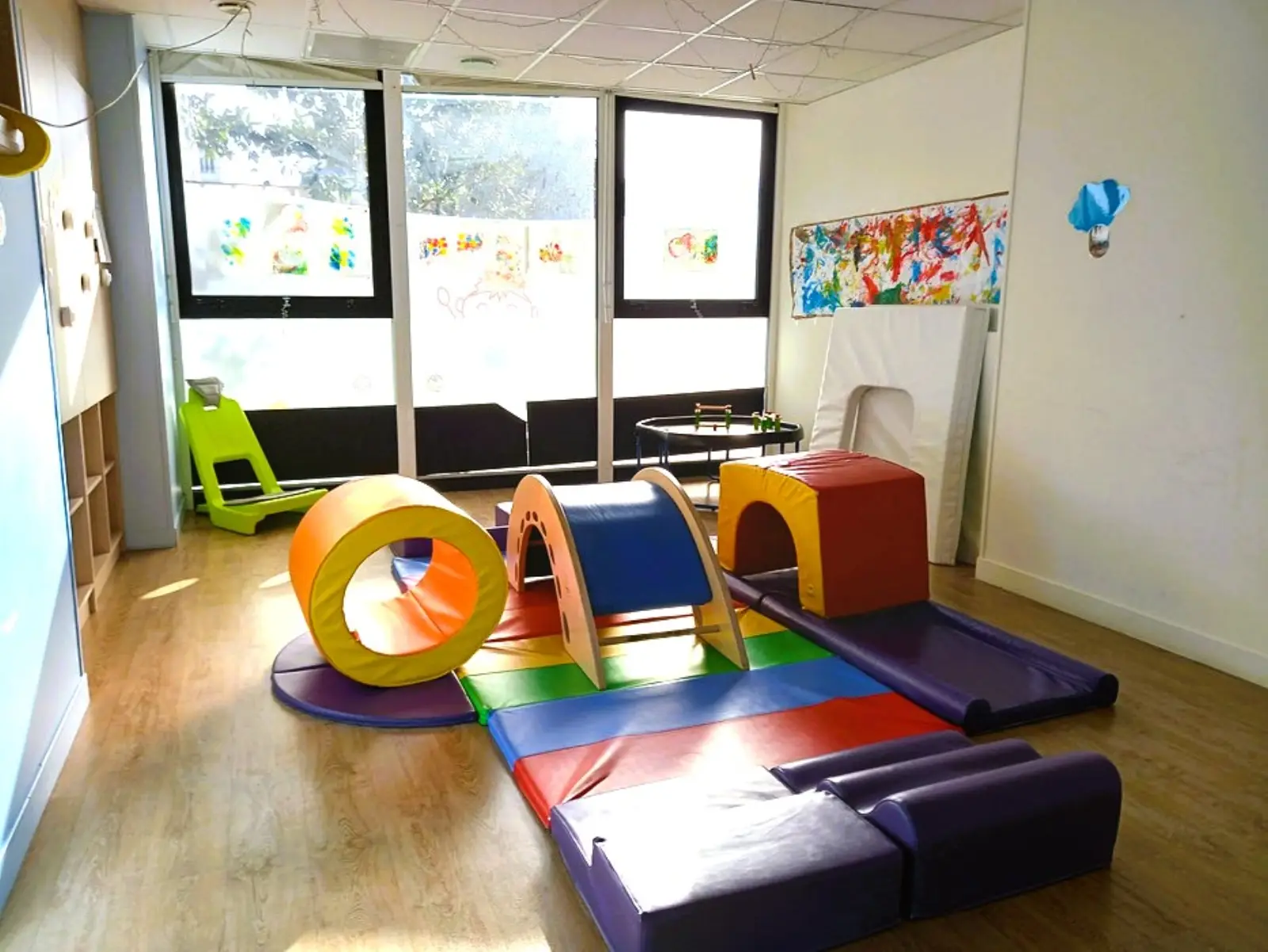 Espace de motricité avec dessins d'enfants aux fenêtres