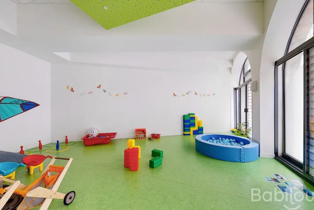 Salle de motricité verte avec piscine à balles à la crèche Babilou Lyon Poulaillerie