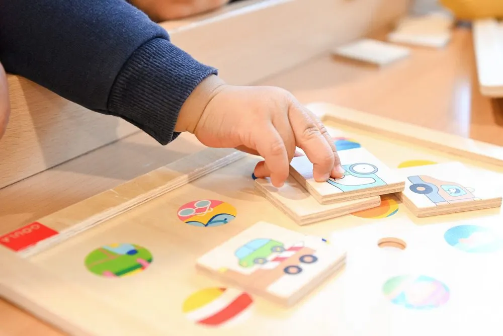 Jeu de puzzle en bois manipulé par un enfant à la crèche Babilou Lyon Petites Sœurs