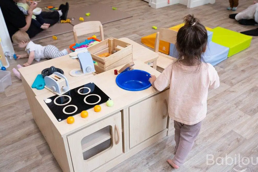 Jeu d'imitation à la cuisine en bois à la micro-crèche Babilou Lyon Tronchet