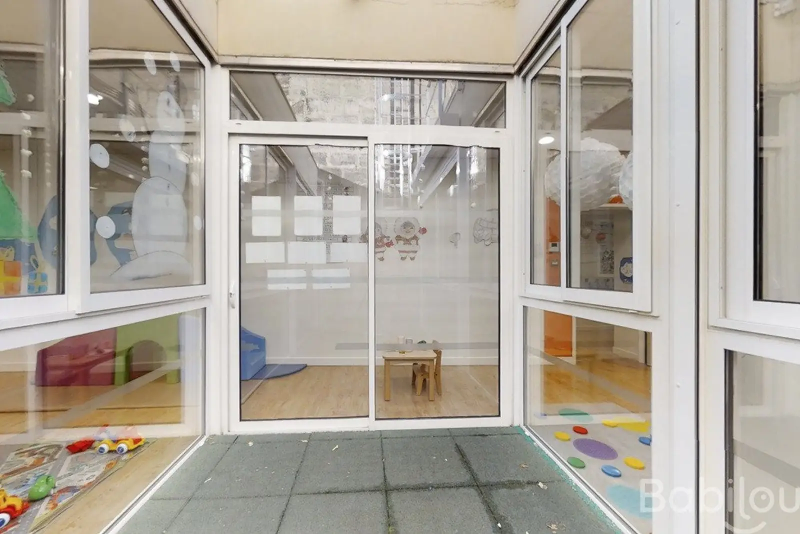 Entrée vitrée donnant sur la cour extérieure de la crèche Babilou Bordeaux Naujac