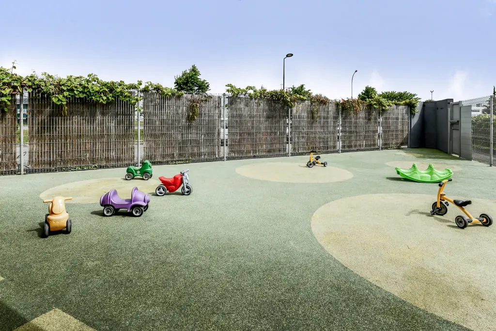 Espace extérieur avec tricycles et porteurs de la crèche Babilou Bruguières Euronord