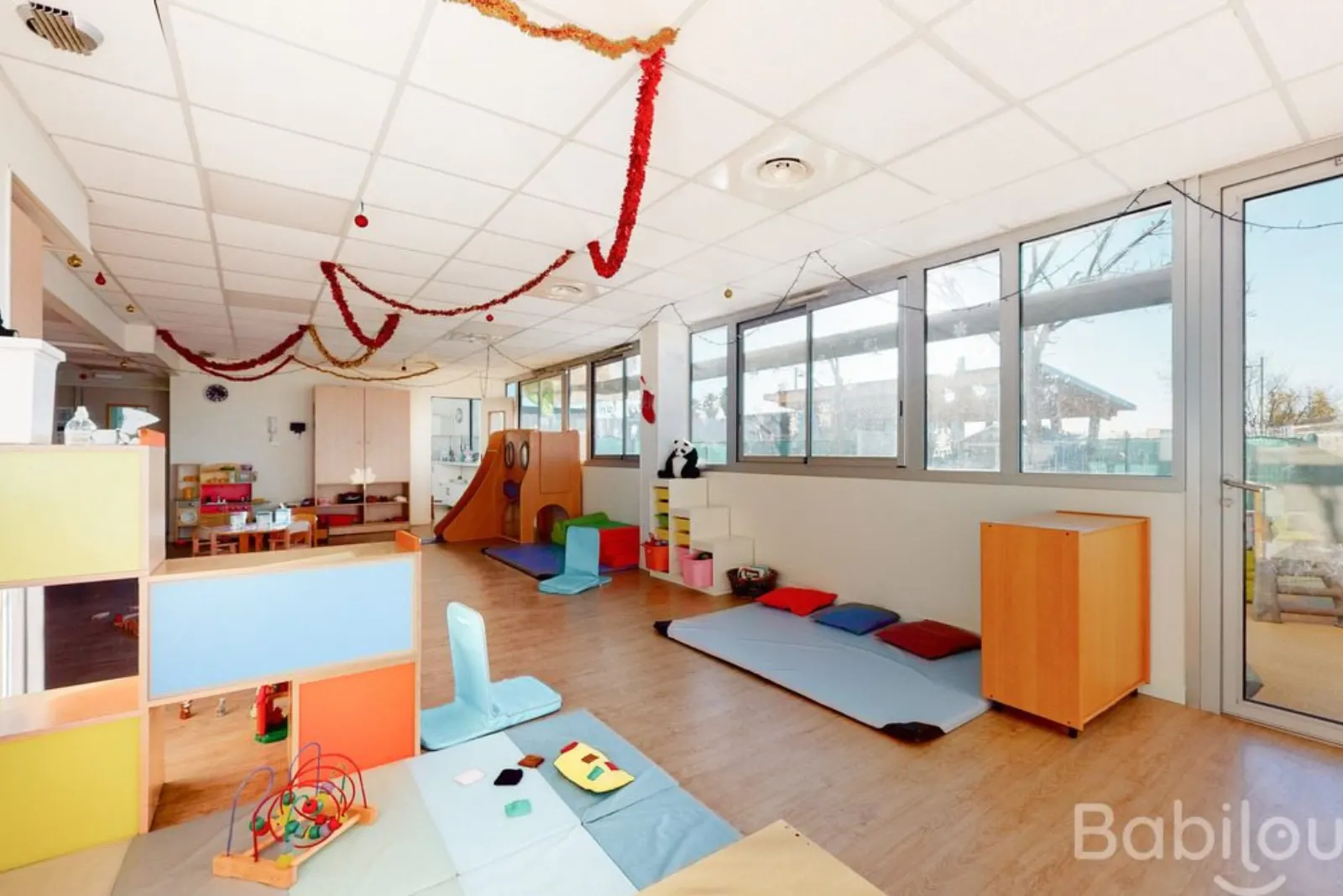 Salle de motricité colorée avec toboggan à la crèche Babilou Saint Aunes Saladelle